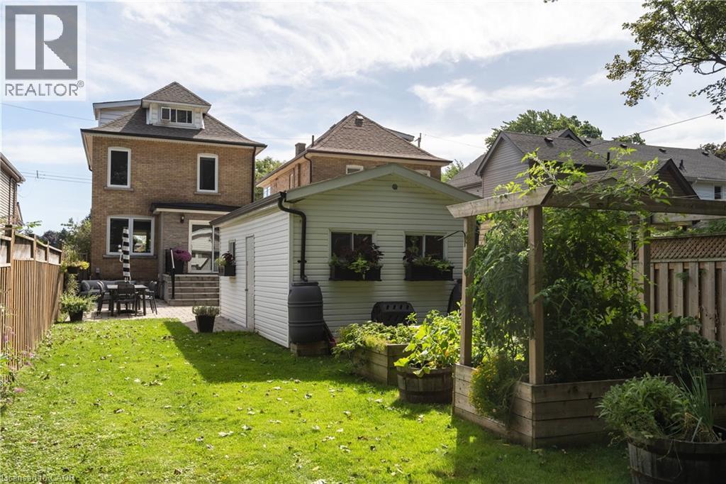 Expansive green lawn with a paver patio and an outdoor dining area - 50 Norway Avenue, Hamilton, ON