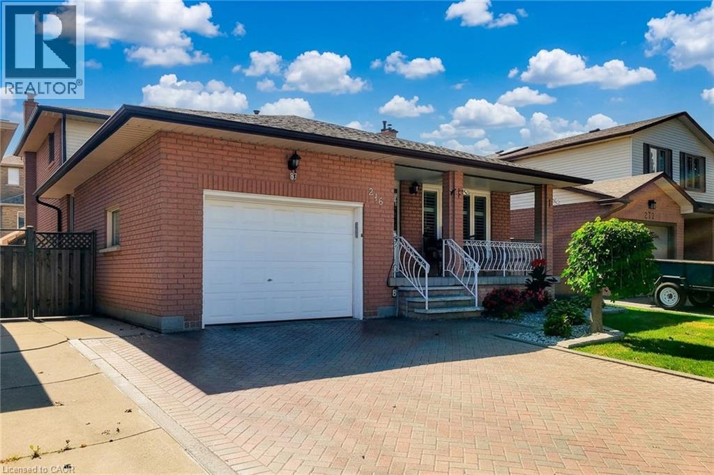 Brick exterior with a covered porch, white railing, and a single-car garage - 276 Greencedar Drive, Hamilton, ON