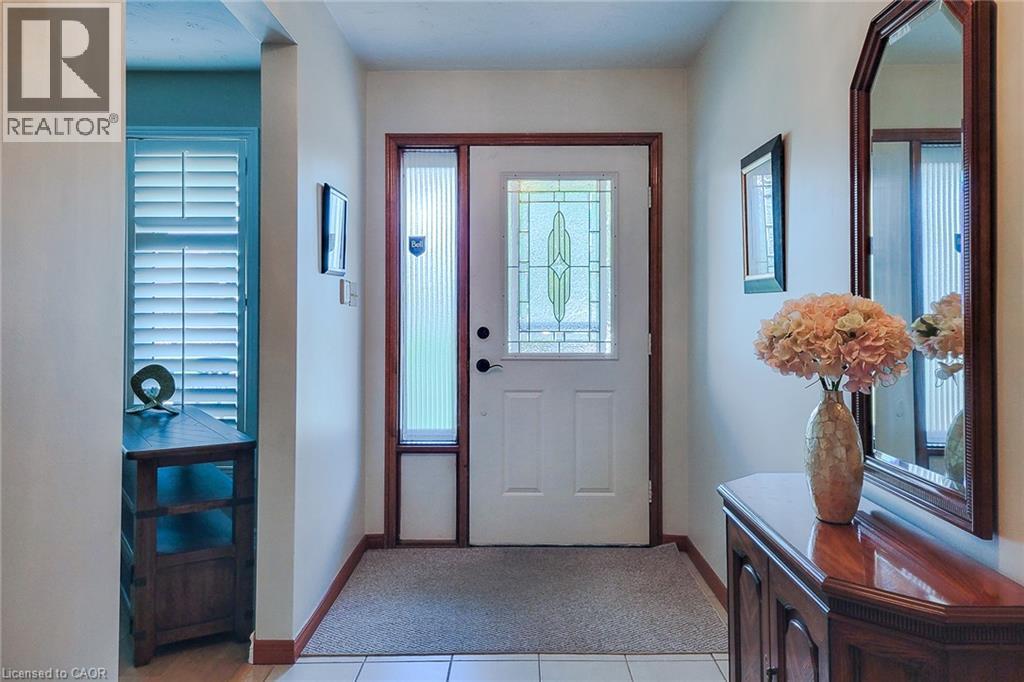 Entryway featuring a decorative glass panel door, a fluted glass sidelight, and wood-finish trim - 276 Greencedar Drive, Hamilton, ON