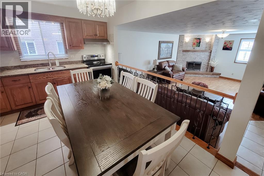 Kitchen with wood cabinetry, stainless steel appliances, and tiled flooring - 276 Greencedar Drive, Hamilton, ON