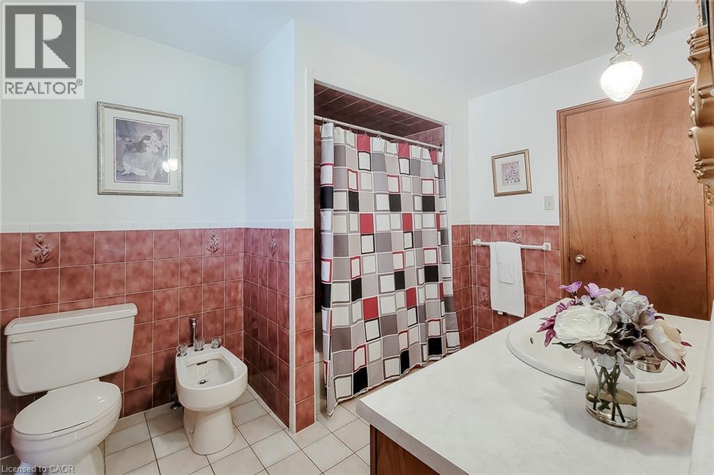 White tile flooring with coordinating red-toned tile wainscoting - 276 Greencedar Drive, Hamilton, ON