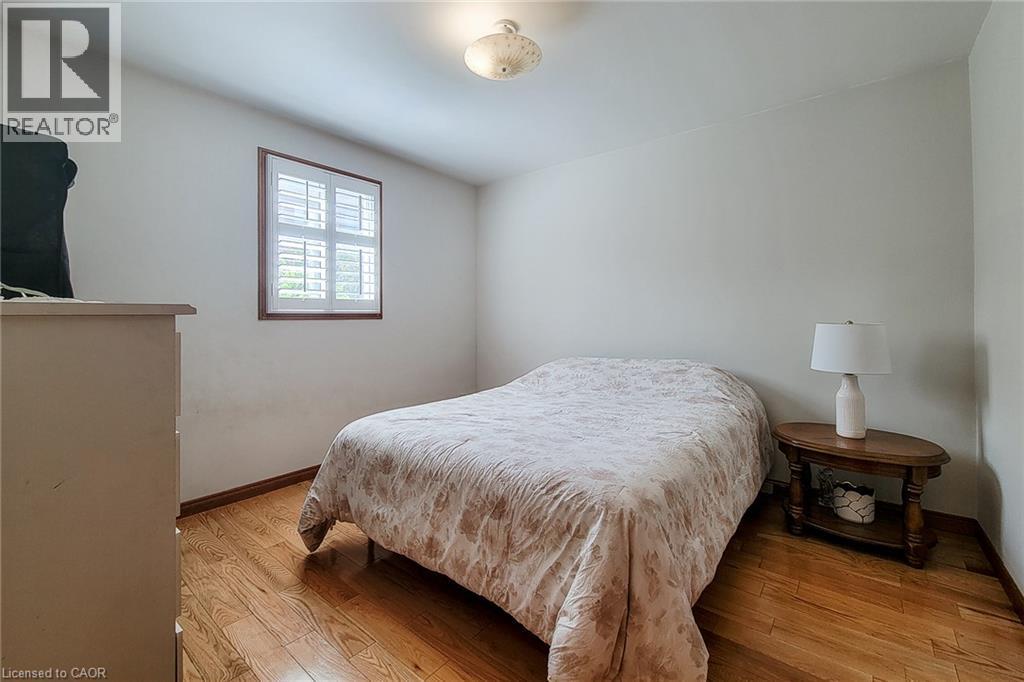 Hardwood flooring, neutral wall tones, window with plantation shutters, and a ceiling-mounted light fixture - 276 Greencedar Drive, Hamilton, ON