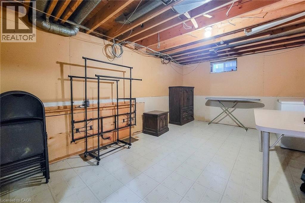 Unfinished basement with exposed ceiling joists, light-colored walls, and tiled flooring - 276 Greencedar Drive, Hamilton, ON