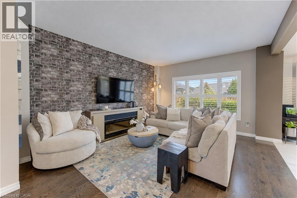 Wood-finish flooring throughout, complemented by a textured accent wall - 428 Freure Drive, Cambridge, ON