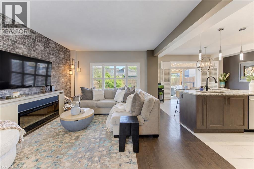 Exposed brick-finish accent wall with an integrated electric fireplace - 428 Freure Drive, Cambridge, ON
