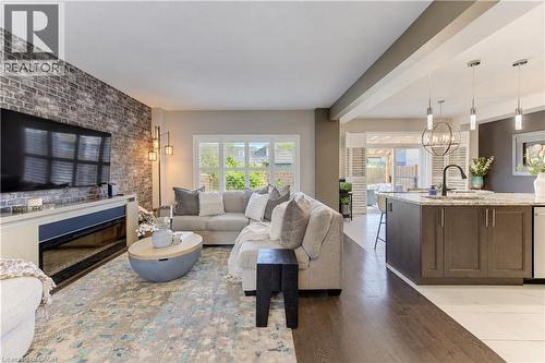 Exposed brick-finish accent wall with an integrated electric fireplace - 428 Freure Drive, Cambridge, ON 