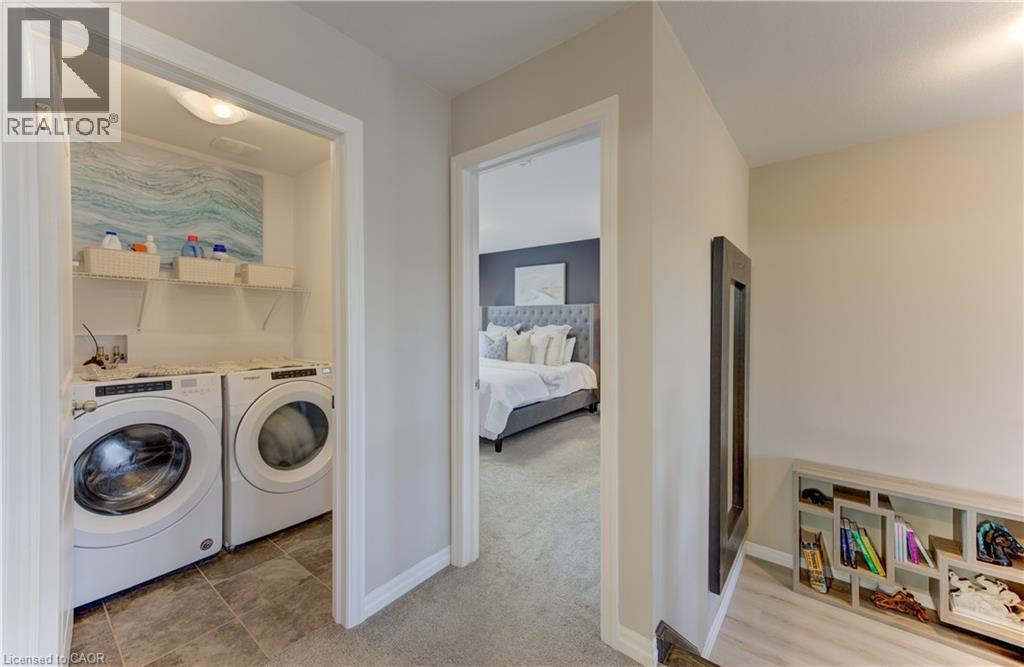 Dedicated laundry area with tile flooring and built-in shelving - 428 Freure Drive, Cambridge, ON