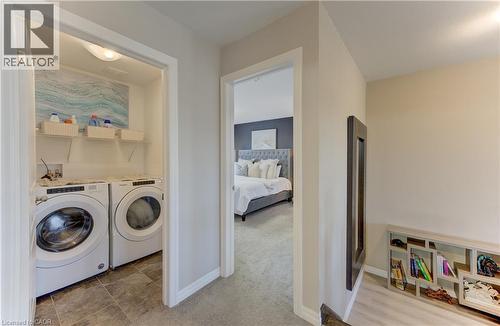 Dedicated laundry area with tile flooring and built-in shelving - 428 Freure Drive, Cambridge, ON 