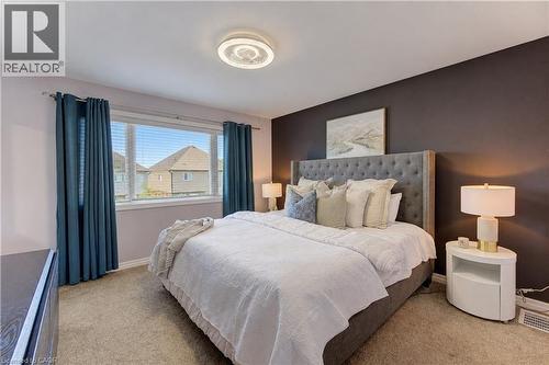 Carpeted flooring, a wide window with blinds, and a built-in overhead light fixture - 428 Freure Drive, Cambridge, ON 