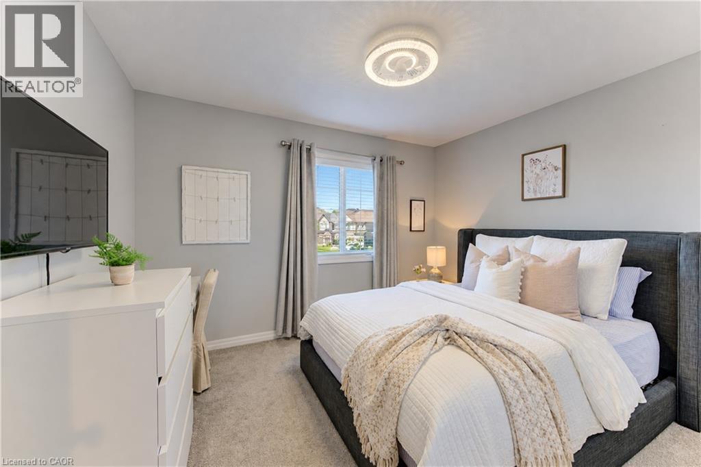 Carpeted room featuring a ceiling-mounted light fixture, window with blinds, and painted walls - 428 Freure Drive, Cambridge, ON