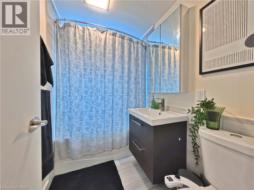 Vanity with integrated sink, coordinating wall-mounted medicine cabinet, and white subway tile wainscoting - 380 Grangewood Drive, Waterloo, ON