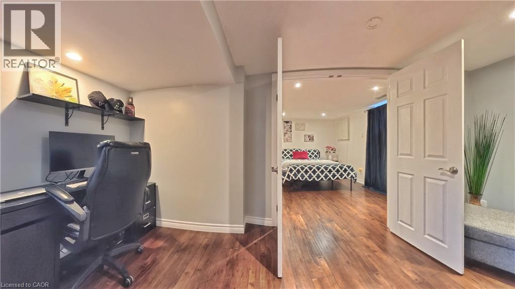 Wood-finish flooring throughout, recessed lighting, white interior doors, and a built-in desk with shelving - 380 Grangewood Drive, Waterloo, ON
