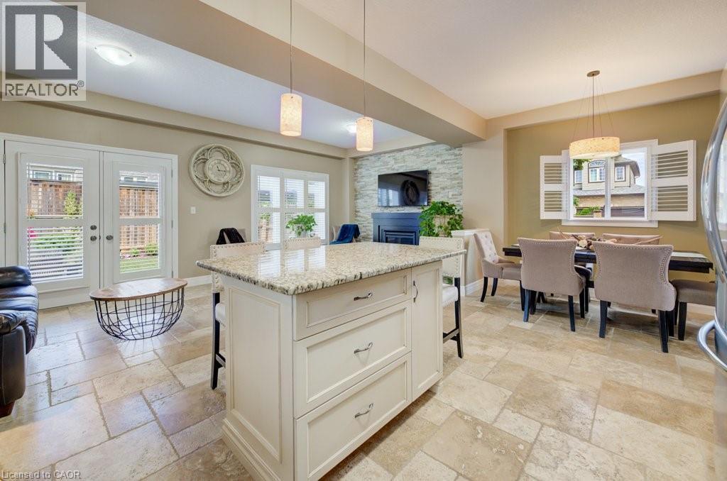 Kitchen island featuring a granite countertop and built-in storage - 300 Watervale Crescent, Kitchener, ON