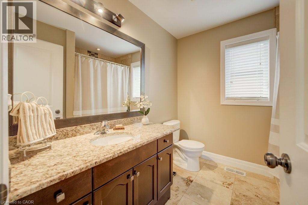 Bathroom featuring a vanity with a light-toned countertop, under-mount sink, and dark wood cabinetry - 300 Watervale Crescent, Kitchener, ON