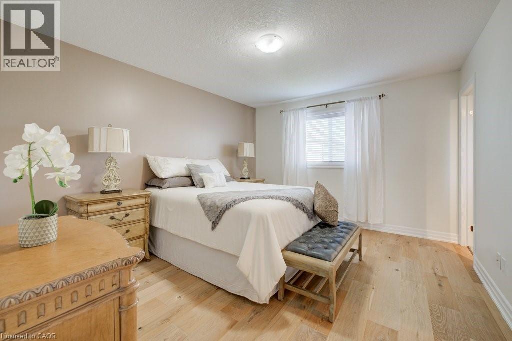 Bedroom featuring light wood-finish flooring, a window with horizontal blinds, and a neutral color palette - 300 Watervale Crescent, Kitchener, ON