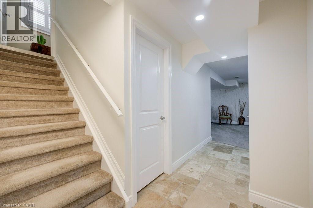 Carpeted staircase with white handrail and baseboards - 300 Watervale Crescent, Kitchener, ON