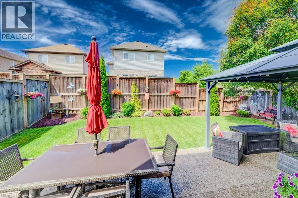 Expansive backyard featuring a manicured lawn, established landscaping, and a privacy fence - 300 Watervale Crescent, Kitchener, ON