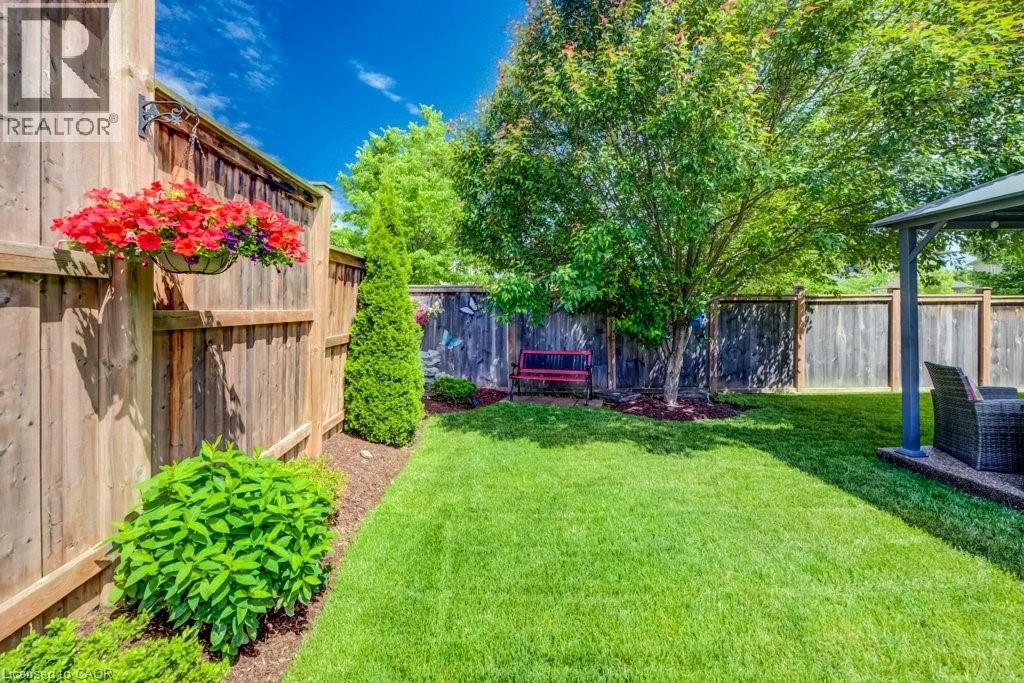 Expansive backyard featuring a manicured lawn, established privacy fencing, mature trees, and a dedicated patio area with a gazebo - 300 Watervale Crescent, Kitchener, ON
