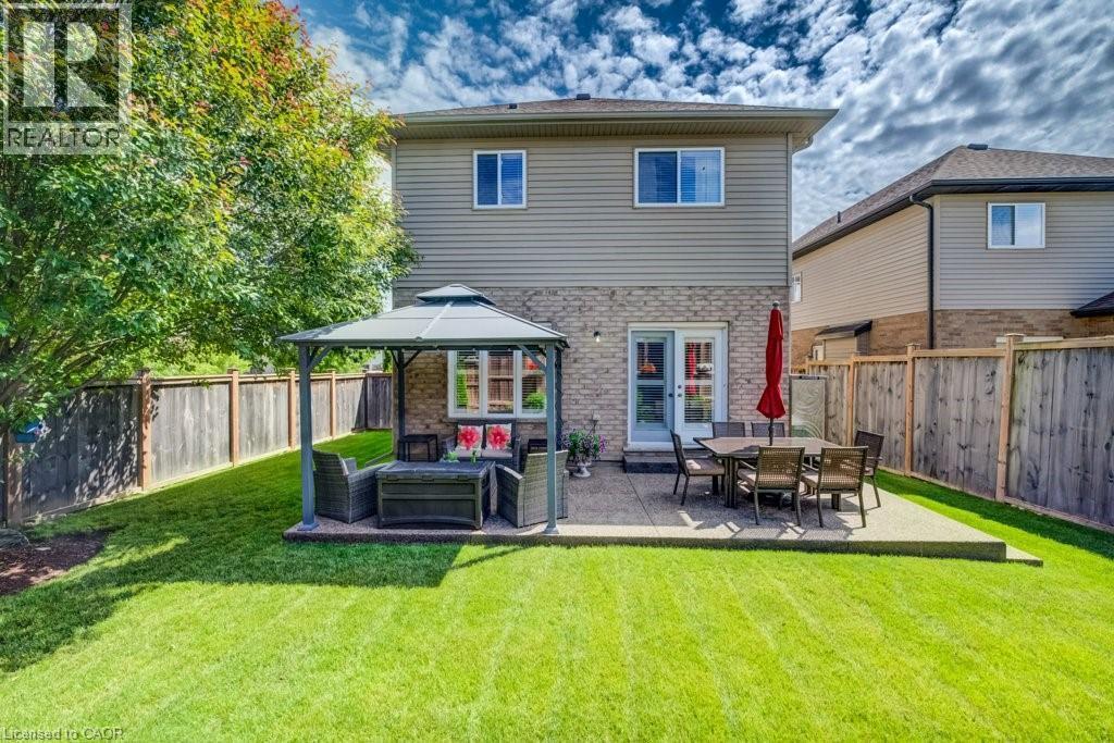 Expansive backyard featuring a manicured lawn, a concrete patio, and a privacy fence - 300 Watervale Crescent, Kitchener, ON