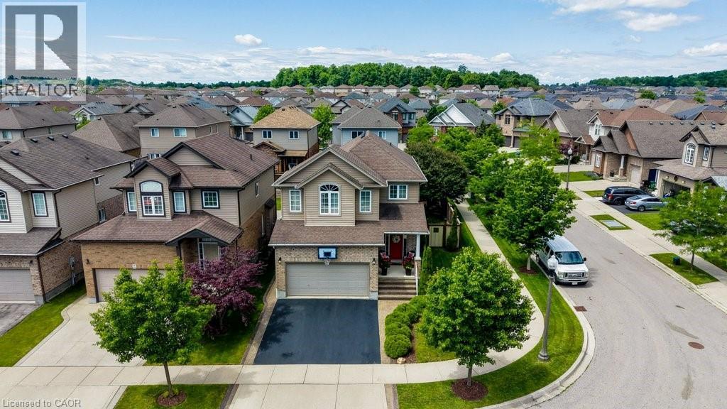 Two-story residence featuring a neutral-toned exterior, an attached garage with a paved driveway, and mature landscaping - 300 Watervale Crescent, Kitchener, ON