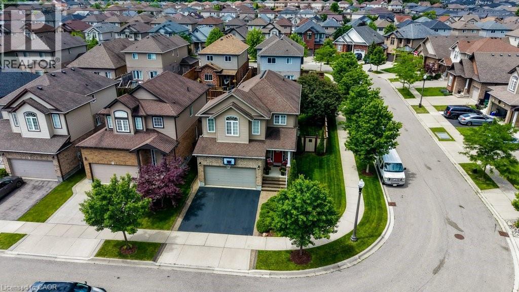 Suburban residence featuring a two-story exterior, attached garage with a paved driveway, mature trees, and a manicured lawn - 300 Watervale Crescent, Kitchener, ON
