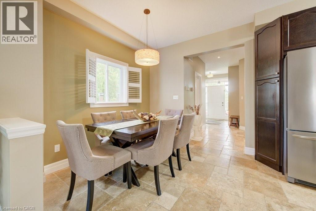 Dining area featuring a contemporary pendant light fixture, window with white plantation shutters, and light-toned tile flooring - 300 Watervale Crescent, Kitchener, ON