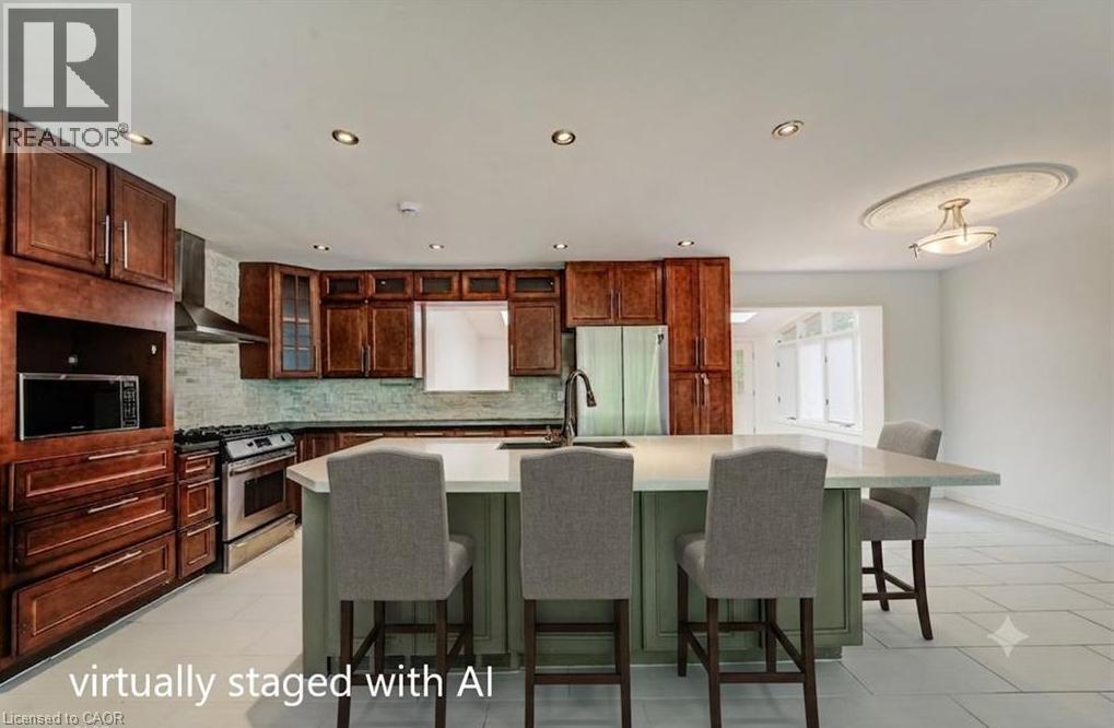 Kitchen featuring wood cabinetry, stainless steel appliances, a center island with countertop seating, recessed lighting, and tile flooring - 109 White Oak Place, Waterloo, ON - Indoor