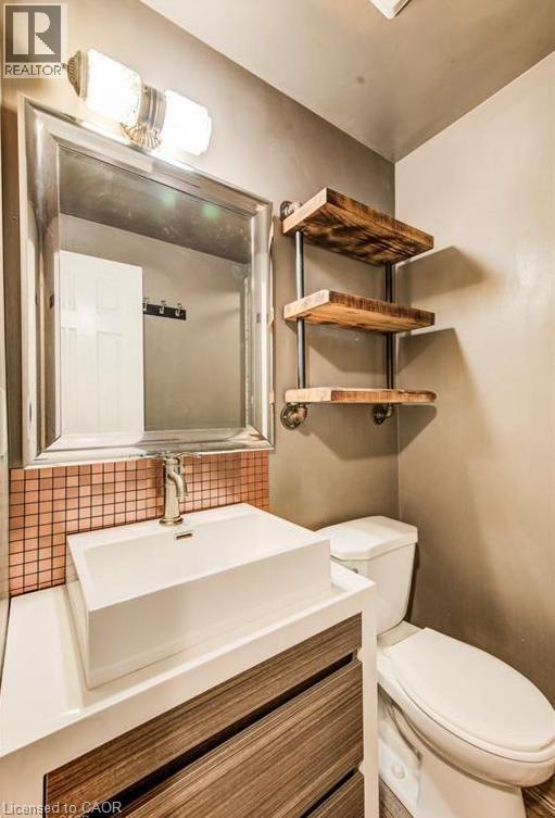 Vessel sink with a wood-finish vanity and mosaic tile backsplash. - 109 White Oak Place, Waterloo, ON - Indoor Photo Showing Bathroom