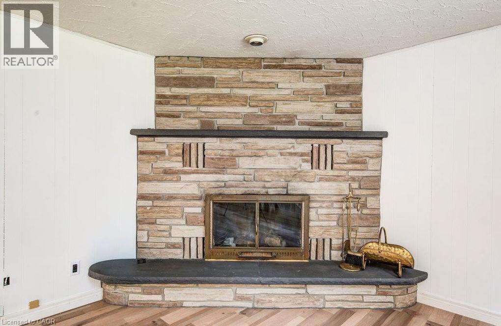 Stone-clad fireplace with a dark stone hearth and mantel. - 109 White Oak Place, Waterloo, ON - Indoor With Fireplace