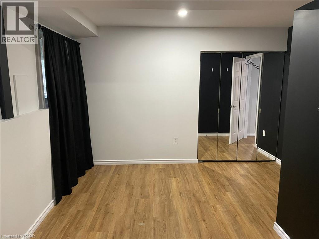 Wood-finish flooring with white baseboards - 47 Queensway Drive, Strathroy, ON - Indoor Photo Showing Other Room