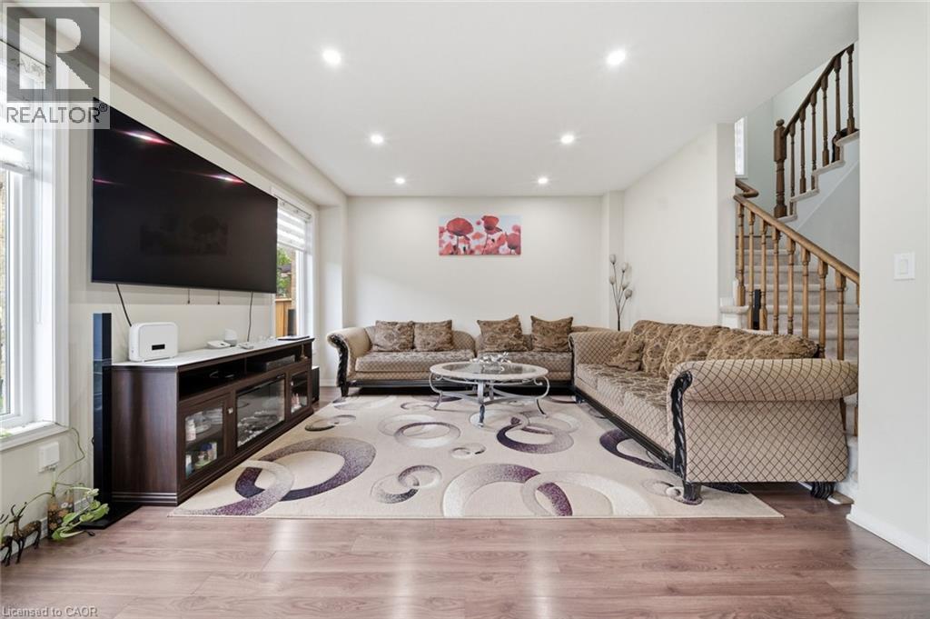 Recessed ceiling lighting, wood-finish flooring, white walls, and staircase with wood railing - 57 Cheevers Road, Brantford, ON - Indoor Photo Showing Other Room