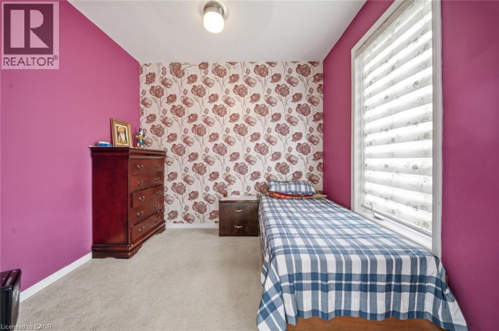 Window with horizontal blinds and light-toned trim, complemented by patterned wallpaper and wall-to-wall carpeting - 57 Cheevers Road, Brantford, ON - Indoor Photo Showing Bedroom