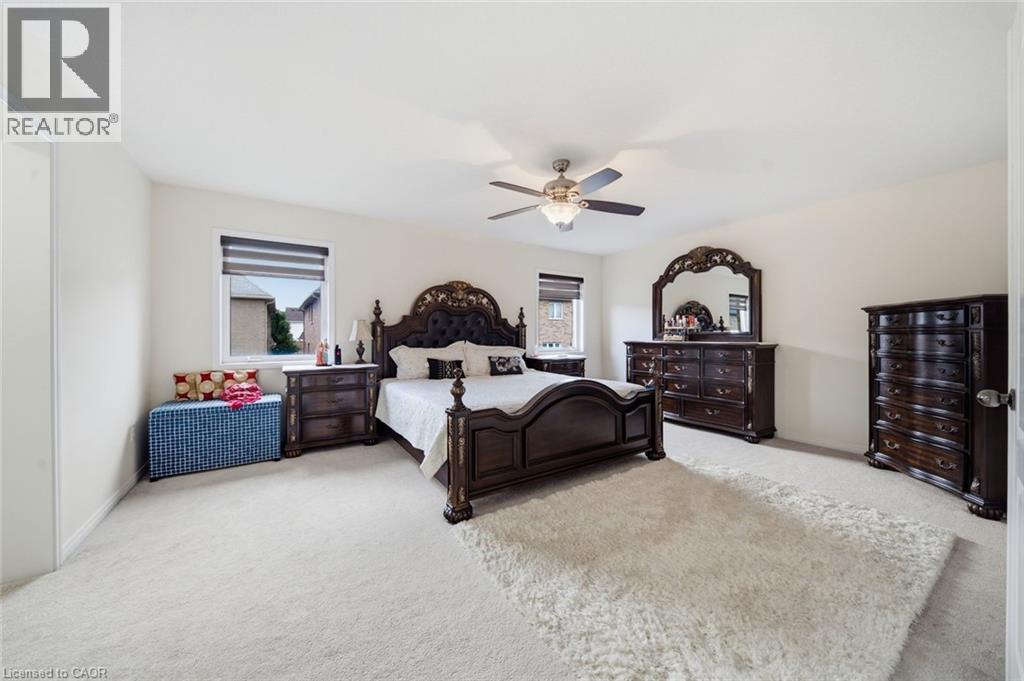 Carpeted flooring, ceiling fan with integrated lighting, and multiple windows with blinds - 57 Cheevers Road, Brantford, ON - Indoor