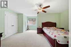 Wall-to-wall carpeting with a ceiling fan light fixture, window with blinds, and white bi-fold closet doors - 
