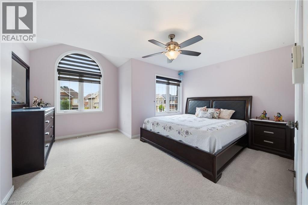Arched window with integrated blinds, vaulted ceiling, ceiling fan with illumination, and plush carpet flooring - 57 Cheevers Road, Brantford, ON - Indoor Photo Showing Bedroom