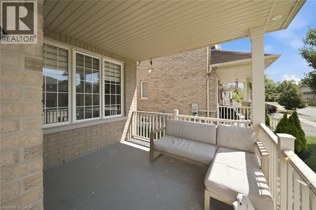 Covered front porch featuring a light brick exterior and white railing - 57 Cheevers Road, Brantford, ON - Outdoor With Exterior