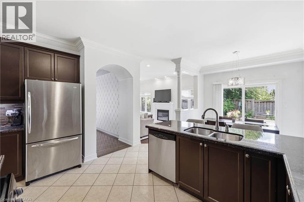 Kitchen featuring stainless steel appliances, dark cabinetry, and granite countertops - 738 Fourth Line, Milton, ON - Indoor Photo Showing Kitchen With Double Sink