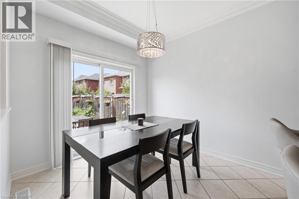 Sliding glass door leading to the exterior, crown molding, tile flooring, and a decorative pendant light fixture - 738 Fourth Line, Milton, ON - Indoor Photo Showing Dining Room