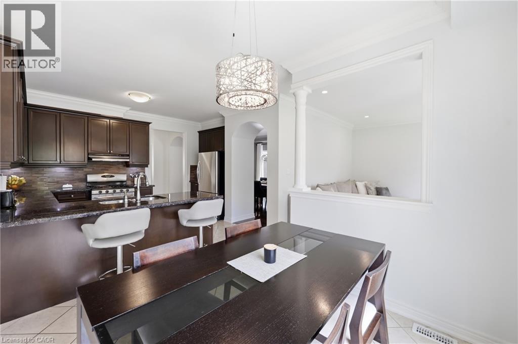 Kitchen featuring dark wood cabinetry, a built-in stainless steel range, and a breakfast bar with stone countertops - 738 Fourth Line, Milton, ON - Indoor Photo Showing Dining Room