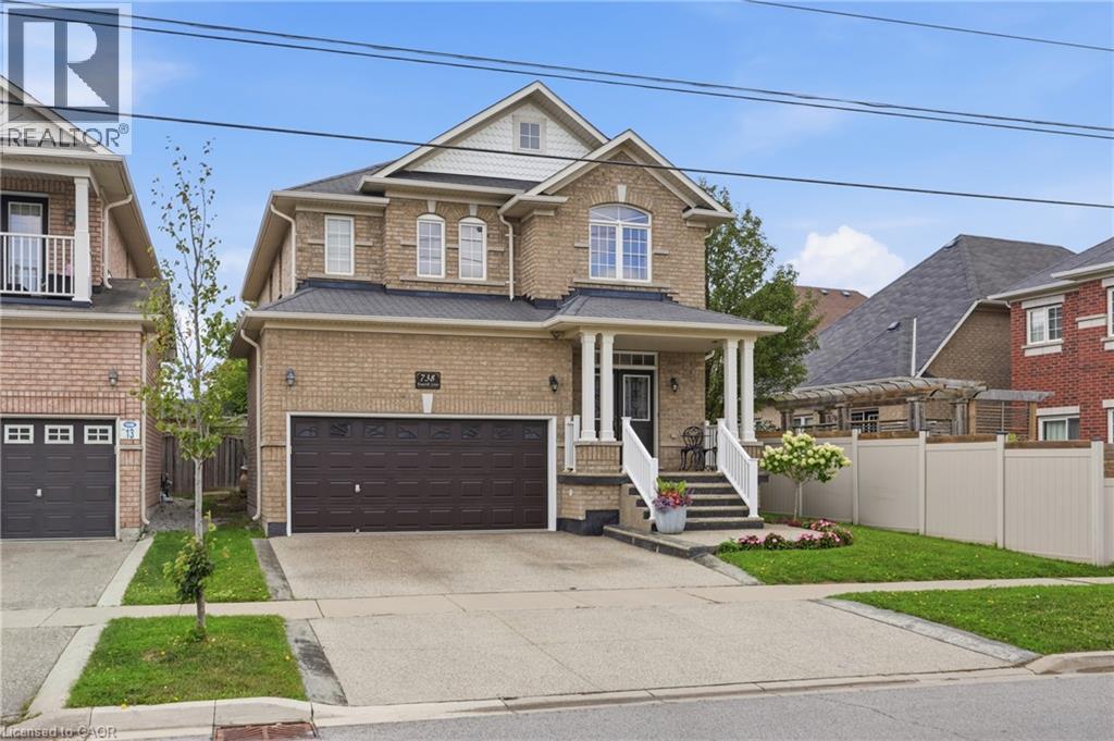 Brick exterior with a covered front porch featuring white columns and railings - 738 Fourth Line, Milton, ON - Outdoor With Facade