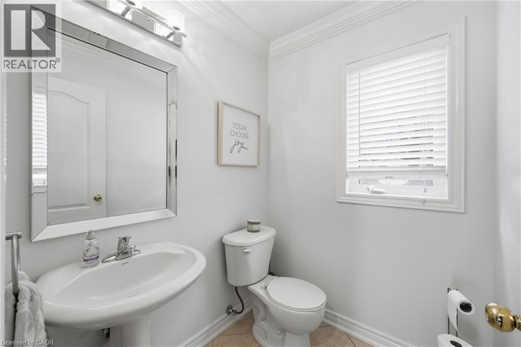 Pedestal sink with chrome faucet, beveled mirror, and wall-mounted light fixture - 738 Fourth Line, Milton, ON - Indoor Photo Showing Bathroom