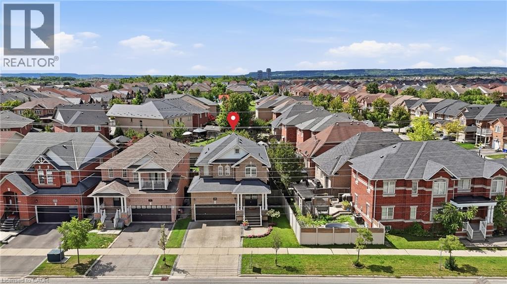 Residential neighborhood featuring detached homes with brick and siding exteriors, attached garages, and paved driveways - 738 Fourth Line, Milton, ON - Outdoor With Facade
