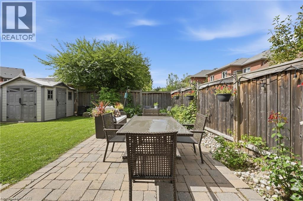 Expansive backyard featuring a paver patio, manicured lawn, and a storage shed - 738 Fourth Line, Milton, ON - Outdoor With Deck Patio Veranda