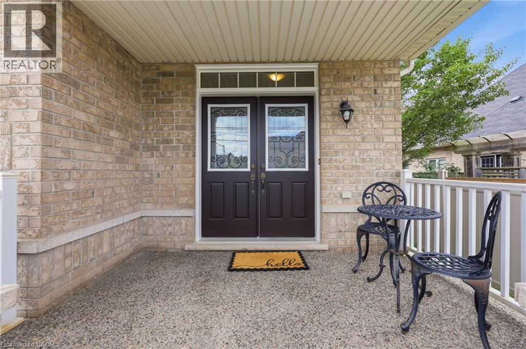 Brick exterior with a covered porch, double entry doors featuring decorative glass, and a transom window - 738 Fourth Line, Milton, ON - Outdoor With Exterior