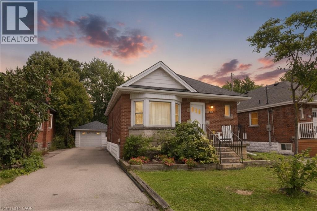 Brick exterior with a bay window, a paved driveway, and a detached garage - 575 Upper Wentworth Street, Hamilton, ON - Outdoor