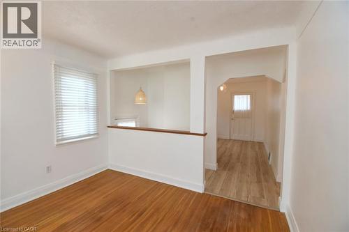 Bright open-concept living area featuring warm wood-finish flooring, white walls, and abundant natural light from a large window - 575 Upper Wentworth Street, Hamilton, ON - Indoor Photo Showing Other Room