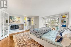 Primary bedroom with gas fireplace & lake view - 