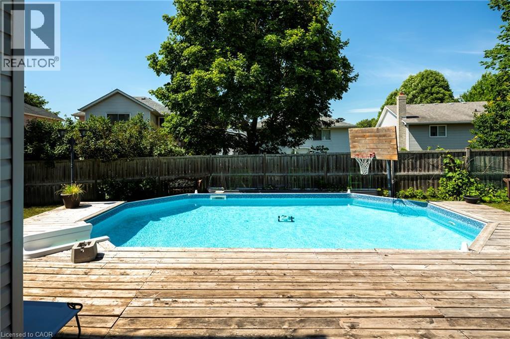 Backyard featuring a built-in swimming pool with a surrounding wood-finish deck - 364 Stoneheight Place, Waterloo, ON