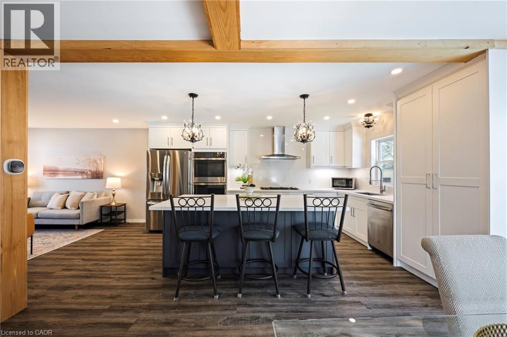 Spacious kitchen featuring a central island with seating, white cabinetry, stainless steel appliances, and recessed lighting - 364 Stoneheight Place, Waterloo, ON