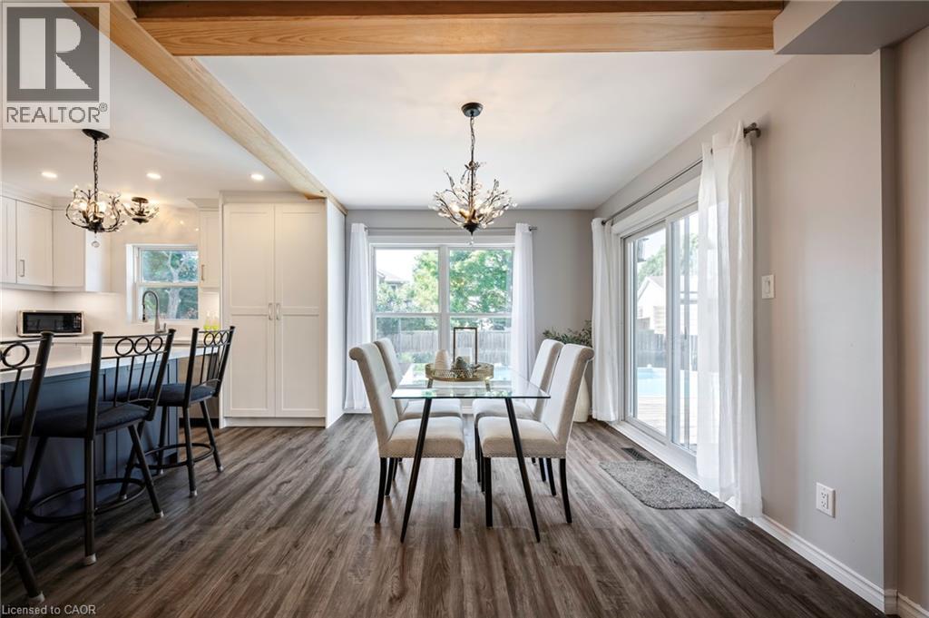 Open-concept living area featuring wood-finish flooring, exposed ceiling beams, and recessed lighting - 364 Stoneheight Place, Waterloo, ON
